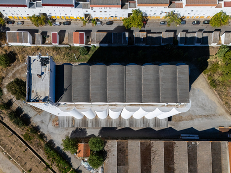 Aerial view of the grain silo with its distinctive white cylindrical storage units and gray roof situated in an industrial area in Evora Evora District Portugal. Aerial view of the grain silo with its distinctive white cylindrical storage units and gray roof situated in an industrial area in Evora Evora District Portugal.