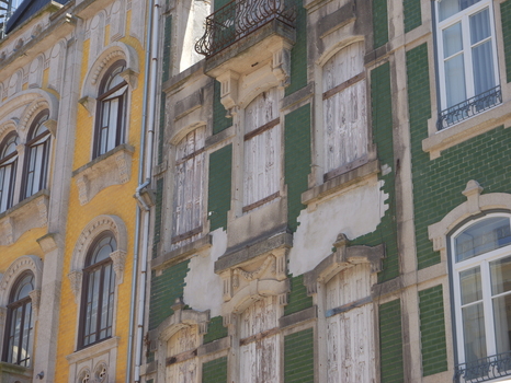 View of historic buildings featuring traditional colorful tiles and weathered wooden shutters in the city center of Porto Porto District Portugal. View of historic buildings featuring traditional colorful tiles and weathered wooden shutters in the city center of Porto Porto District Portugal.