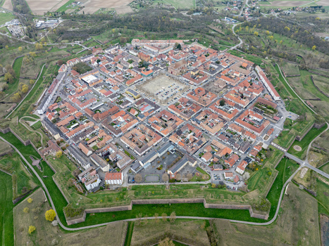Aerial view of the star shaped fortress city with its symmetrical layout and red tiled roofs surrounded by lush green moats Neuf Brisach Grand Est France.