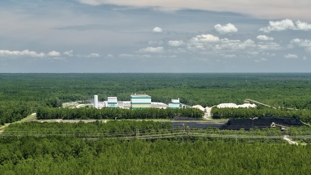 Aerial view of Seminole Electric Fuel Tanks surrounded by dense forest and coal piles in Palatka Florida United States.