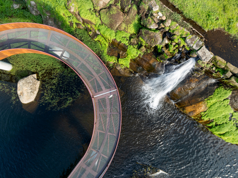 Aerial view of the Acude da Ribeira circular walkway over a river with mossy rocks and lush greenery in Ervedal Coimbra Portugal. Aerial view of the Acude da Ribeira circular walkway over a river with mossy rocks and lush greenery in Ervedal Coimbra Portugal.