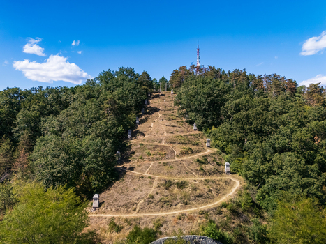 Aerial view of the Three Cross Calvary a hillside Stations of the Cross trail with stone shrines and crosses amid summer woodland in Salgotarjan Hungary. Aerial view of the Three Cross Calvary a hillside Stations of the Cross trail with stone shrines and crosses amid summer woodland in Salgotarjan Hungary.
