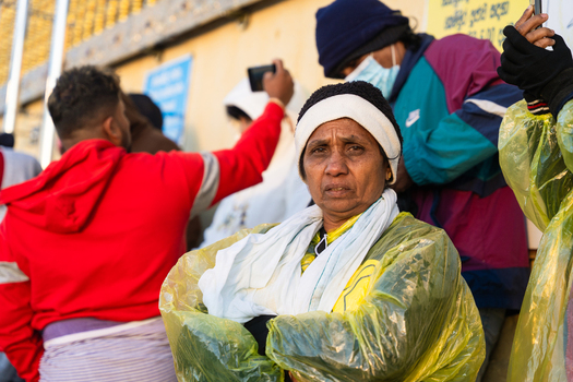 Ratnapura Sri Lanka 23 February 2026 View of pilgrims including a woman in a yellow raincoat gathered at Adam s Peak during the pilgrimage season.