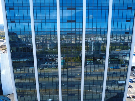 Aerial view of a modern glass skyscraper reflecting the surrounding urban landscape and traffic in Sofia Sofia City Province Bulgaria. Aerial view of a modern glass skyscraper reflecting the surrounding urban landscape and traffic in Sofia Sofia City Province Bulgaria.