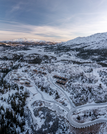 Aerial view of Gaustablikk Fjellresort nestled in the snow covered mountains with winding roads and pine forests in Rjukan Telemark Norway. Aerial view of Gaustablikk Fjellresort nestled in the snow covered mountains with winding roads and pine forests in Rjukan Telemark Norway.