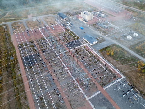 Aerial view of a high power electricity substation with complex power lines transformers and industrial buildings surrounded by forest in Muhos North Ostrobothnia Finland.