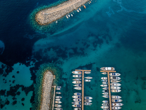 Aerial view of boats docked in the marina contrasting against the azure waters surrounding the harbor Mgarr Harbour Gozo Malta. Aerial view of boats docked in the marina contrasting against the azure waters surrounding the harbor Mgarr Harbour Gozo Malta.