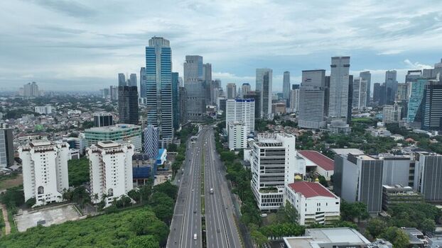 Aerial view of the modern skyline and highway infrastructure in the Pancoran district surrounded by dense urban development and greenery in Pancoran Jakarta Indonesia.