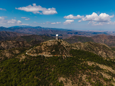 Aerial view of the Kionia radar station atop a mountain peak surrounded by lush green forests and winding roads in the Troodos Mountains near Lazanias Lefkosia Cyprus. Aerial view of the Kionia radar station atop a mountain peak surrounded by lush green forests and winding roads in the Troodos Mountains near Lazanias Lefkosia Cyprus.