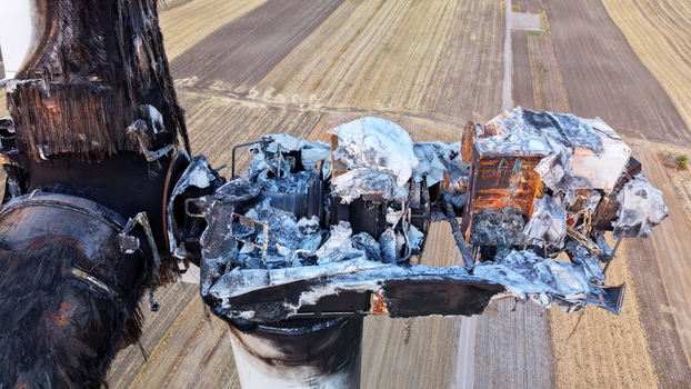 Aerial view of the charred and destroyed nacelle of a wind turbine with exposed internal machinery and burnt metal components above agricultural fields in Vladimirovac Vojvodina Serbia.
