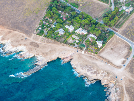 Aerial view of Riserva Naturale Orientata dello Zingaro with coastal cliffs turquoise sea Mediterranean vegetation and residential buildings in San Vito Lo Capo Sicilia Italy. Aerial view of Riserva Naturale Orientata dello Zingaro with coastal cliffs turquoise sea Mediterranean vegetation and residential buildings in San Vito Lo Capo Sicilia Italy.