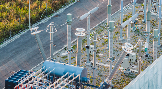 Aerial view of high voltage electrical substation equipment insulators and power transformers at an energy facility in Trino Piedmont Italy. Aerial view of high voltage electrical substation equipment insulators and power transformers at an energy facility in Trino Piedmont Italy.