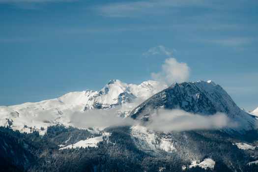 View of snow capped peaks pierce the azure sky their majestic forms softened by wisps of ethereal clouds a winter s tale unfolds Train from Lucerne Switzerland. View of snow capped peaks pierce the azure sky their majestic forms softened by wisps of ethereal clouds a winter s tale unfolds Train from Lucerne Switzerland.