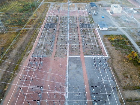 Aerial view of high power electricity infrastructure with power lines transformers and industrial equipment at a substation in Muhos North Ostrobothnia Finland.