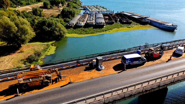 Aerial view of Smederevo bridge and shipyard with construction equipment on the road and barges docked along the Danube river in Smederevo Podunavlje District Serbia.
