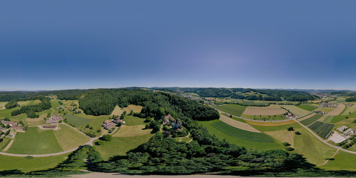 Aerial view of Liebegg Castle surrounded by dense green forests and rolling agricultural fields under a clear blue sky in Granichen Aargau Switzerland. Aerial view of Liebegg Castle surrounded by dense green forests and rolling agricultural fields under a clear blue sky in Granichen Aargau Switzerland.