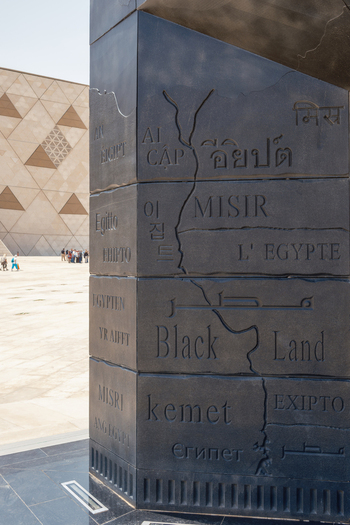Giza Egypt 16 May 2026 View of the Grand Egyptian Museum featuring an inscribed stone pillar with the name of Egypt in various languages and the modern geometric facade.