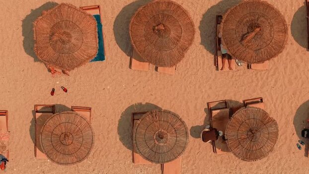 Aerial view of straw umbrellas and sun loungers on a beach Albania. Aerial view of straw umbrellas and sun loungers on a beach Albania.