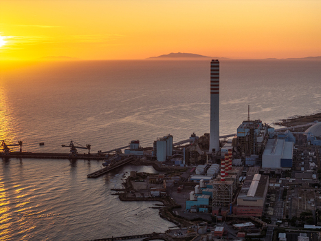 Aerial view of Centrale Termoelettrica Torrevaldaliga Nord power plant along the coast during a vibrant golden sunset Civitavecchia Lazio Italy. Aerial view of Centrale Termoelettrica Torrevaldaliga Nord power plant along the coast during a vibrant golden sunset Civitavecchia Lazio Italy.