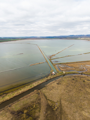 Aerial view of Lake Atanasovsko featuring salt pans and narrow water channels under a cloudy sky in Burgas Burgas Bulgaria. Aerial view of Lake Atanasovsko featuring salt pans and narrow water channels under a cloudy sky in Burgas Burgas Bulgaria.