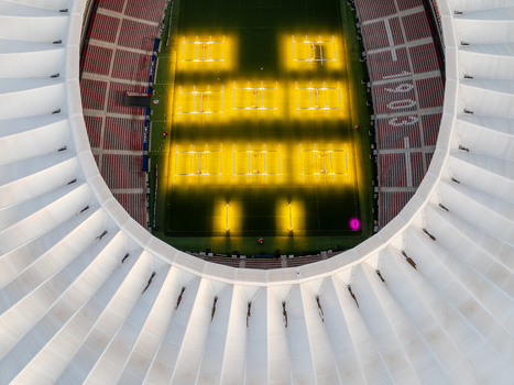 Aerial view of Riyadh Air Metropolitano Stadium featuring the illuminated pitch with specialized turf growth lights and modern architecture in Madrid Comunidad de Madrid Spain.