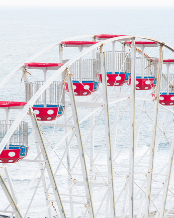 Aerial view of a white Ferris wheel with red polka dot gondolas overlooking the ocean waves Ocean City New Jersey United States.