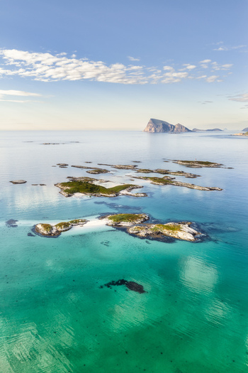 Aerial view of the Sommaroy islands featuring turquoise waters white sand beaches and rocky outcrops under a clear blue sky in Sommaroy Troms Norway. Aerial view of the Sommaroy islands featuring turquoise waters white sand beaches and rocky outcrops under a clear blue sky in Sommaroy Troms Norway.
