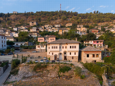 Aerial view of the historic stone architecture of Gjirokaster featuring traditional houses on the hillside and a prominent stone building in Gjirokaster Gjirokaster County Albania. Aerial view of the historic stone architecture of Gjirokaster featuring traditional houses on the hillside and a prominent stone building in Gjirokaster Gjirokaster County Albania.