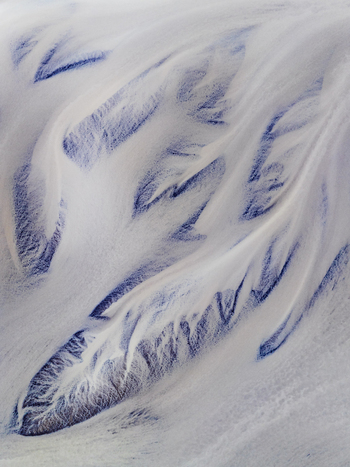 Aerial view of a glacial river delta with intricate branching patterns of sediment laden water and dark volcanic sand in Iceland. Aerial view of a glacial river delta with intricate branching patterns of sediment laden water and dark volcanic sand in Iceland.