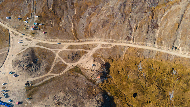 Aerial view of the arid landscape surrounding Sheosar Lake with a winding dirt road and scattered tents in Skardu Gilgit Pakistan.
