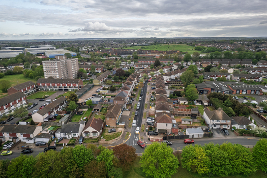 Aerial view of rows of houses and buildings interspersed with lush greenery under a cloudy sky Slade green United Kingdom.