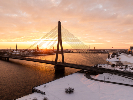 Aerial view of the Vansu Bridge spanning the Daugava River during a golden sunset over the snow covered city of Riga Latvia. Aerial view of the Vansu Bridge spanning the Daugava River during a golden sunset over the snow covered city of Riga Latvia.