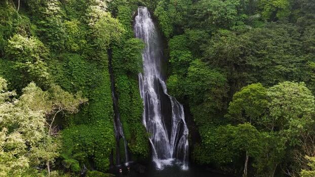 Aerial view of waterfall in lush tropical jungle Indonesia.