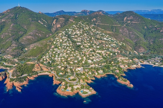 Aerial view of Le Trayas a coastal area with villas on hillsides overlooking the Mediterranean Sea red rocks and blue waters Saint Raphael Provence Alpes Cote d Azur France. Aerial view of Le Trayas a coastal area with villas on hillsides overlooking the Mediterranean Sea red rocks and blue waters Saint Raphael Provence Alpes Cote d Azur France.