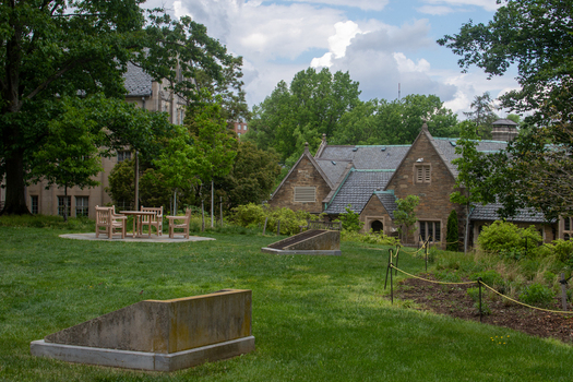 Washington District of Columbia United States 06 May 2025 View of Washington National Cathedral grounds featuring stone architecture green lawns and outdoor seating under a cloudy sky.