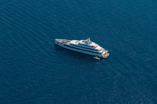 Aerial view of a large luxury yacht cruising on the deep blue Mediterranean Sea off the coast of Antibes Provence Alpes Cote d Azur France. Aerial view of a large luxury yacht cruising on the deep blue Mediterranean Sea off the coast of Antibes Provence Alpes Cote d Azur France.