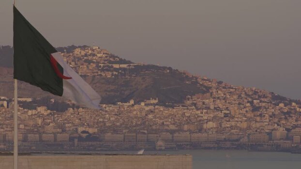 Aerial view of Algerian flag over coastal city Algeria.