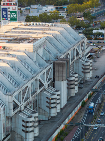 Aerial view of the ICC Berlin a prominent example of Brutalist architecture with its distinctive metallic facade and complex structural design near a highway in Berlin Berlin Germany. Aerial view of the ICC Berlin a prominent example of Brutalist architecture with its distinctive metallic facade and complex structural design near a highway in Berlin Berlin Germany.