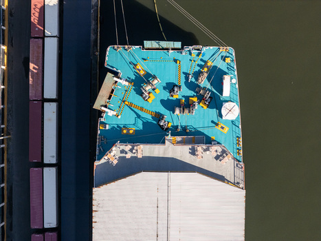 Aerial view of the deck of a cargo ship docked along the Rio Ozama with shipping containers lined up on the pier in Santo Domingo Santo Domingo Dominican Republic.