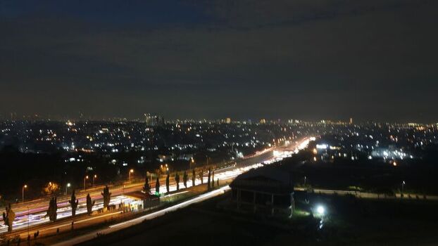 Aerial view of Grand Kota Bintang at night with light trails from traffic on the highway and city lights Kecamatan Bekasi Barat Jawa Barat Indonesia. Aerial view of Grand Kota Bintang at night with light trails from traffic on the highway and city lights Kecamatan Bekasi Barat Jawa Barat Indonesia.