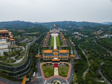 Aerial view of the Fo Guang Shan Buddha Museum with its golden Buddha statue symmetrical pagodas and traditional architecture amidst lush hills in Jiuru Township Pingtung County Taiwan. Aerial view of the Fo Guang Shan Buddha Museum with its golden Buddha statue symmetrical pagodas and traditional architecture amidst lush hills in Jiuru Township Pingtung County Taiwan.