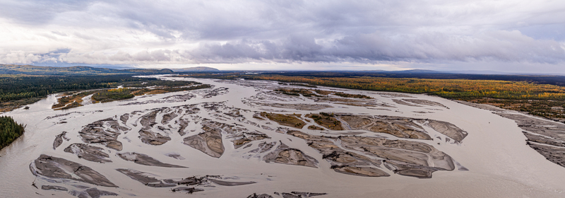 Aerial view of the Tanana River with its braided channels sandbars and surrounding autumn colored boreal forest under a cloudy sky in Yukon Koyukuk Census Area Alaska United States. Aerial view of the Tanana River with its braided channels sandbars and surrounding autumn colored boreal forest under a cloudy sky in Yukon Koyukuk Census Area Alaska United States.