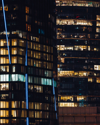 Aerial view of modern offices in the financial district with illuminated windows and glass facades at night in Warsaw Masovian Voivodeship Poland.