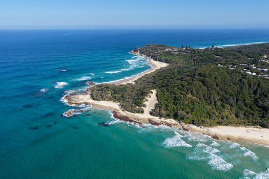 Aerial view of North Stradbroke Island featuring turquoise waters sandy beaches rocky headlands and dense coastal vegetation in Redland City Queensland Australia. Aerial view of North Stradbroke Island featuring turquoise waters sandy beaches rocky headlands and dense coastal vegetation in Redland City Queensland Australia.