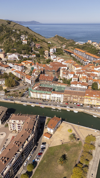 Aerial view of the coastal town of Zumaia with its river historic buildings with red tiled roofs and surrounding hills in Zumaia Basque Country Spain.