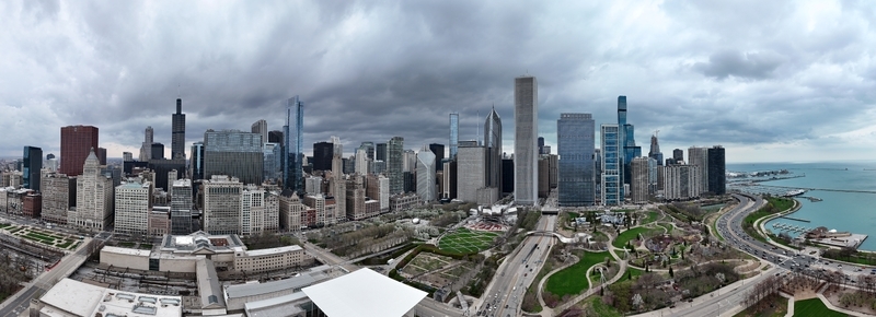 Aerial view of the Chicago skyline featuring Millennium Park the Willis Tower and skyscrapers along the Lake Michigan waterfront under an overcast sky in Chicago. Aerial view of the Chicago skyline featuring Millennium Park the Willis Tower and skyscrapers along the Lake Michigan waterfront under an overcast sky in Chicago.