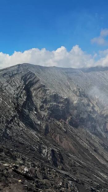 View of volcanic crater with smoke plume Indonesia.