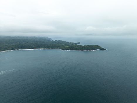 Aerial view of a rugged coastline meeting the vast expanse of the sea where lush greenery contrasts with the deep blue waters Gunungkidul Regency Daerah Istimewa Yogyakarta Indonesia. Aerial view of a rugged coastline meeting the vast expanse of the sea where lush greenery contrasts with the deep blue waters Gunungkidul Regency Daerah Istimewa Yogyakarta Indonesia.