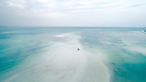 Aerial view of turquoise waters meet the white sands under a vast sky creating a serene coastal panorama Paje Unguja South Region Tanzania.