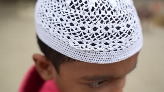 View of a person wearing a white skullcap Bangladesh. View of a person wearing a white skullcap Bangladesh.